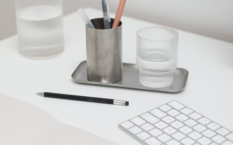 Un bureau de travail dégagé, carnet et tasse.